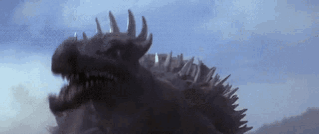 a close up of a monster with sharp teeth and a blue sky in the background
