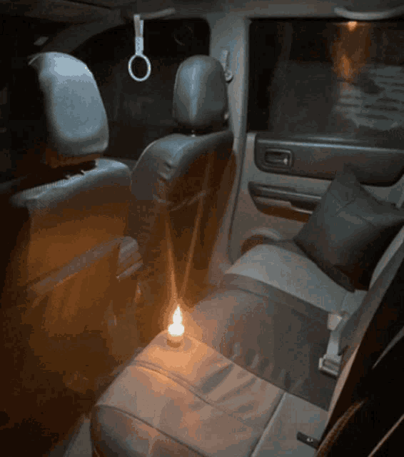 the back seat of a car with a lit candle on the seat