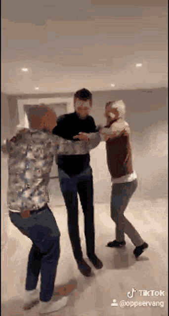 a group of men are dancing together in a room with their arms around each other .