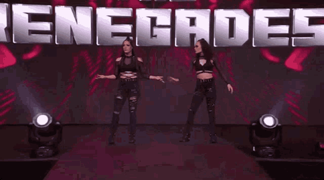 two women standing in front of a sign that says enegade