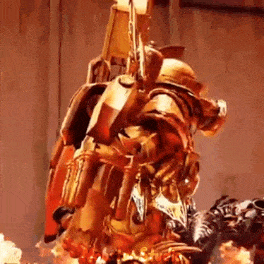 a statue of a robot with a rocket pack on its back is surrounded by flames .
