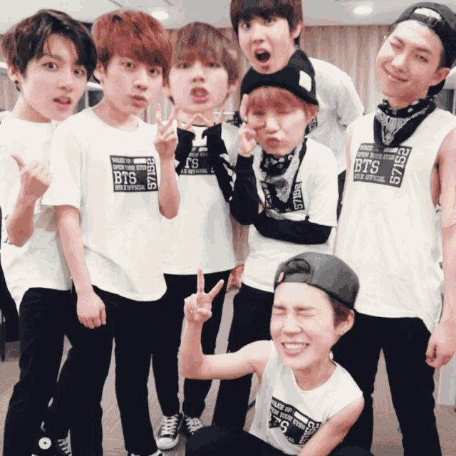 a group of boys wearing shirts that say bts