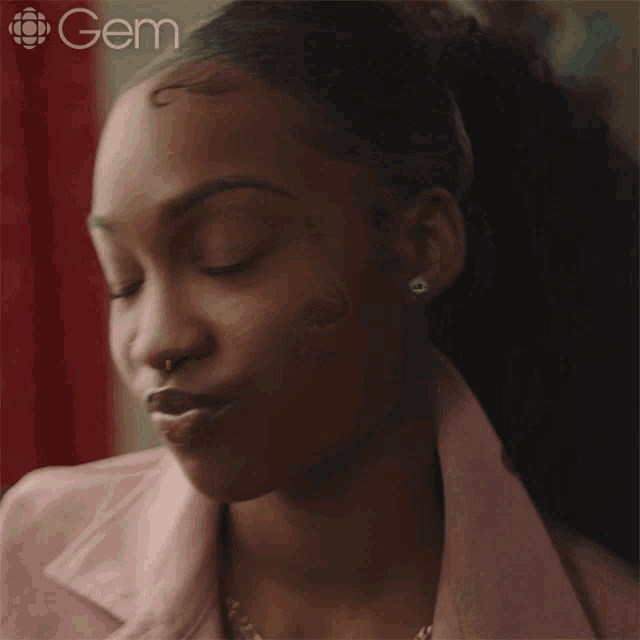 a close up of a woman 's face with the gem logo in the corner