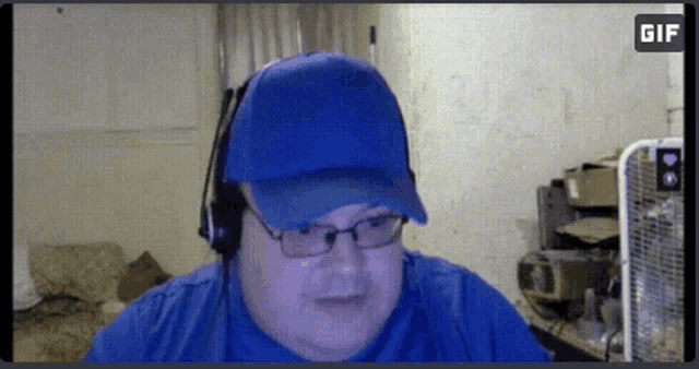 a man wearing a blue hat and headphones is looking at the camera with a gif icon in the corner
