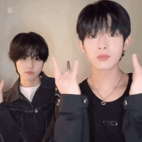 two young men are making devil horns signs with their fingers
