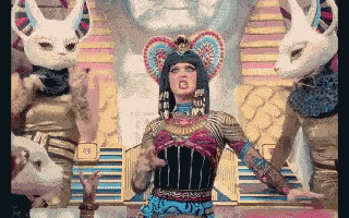 a woman dressed as a pharaoh is surrounded by white rabbits