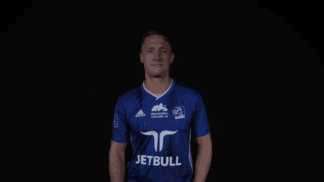 a man wearing a blue shirt that says jetbull on the front