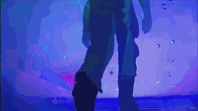 a person standing in a dark room with blue lights
