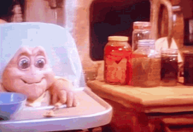 a baby in a high chair with a spoon in it