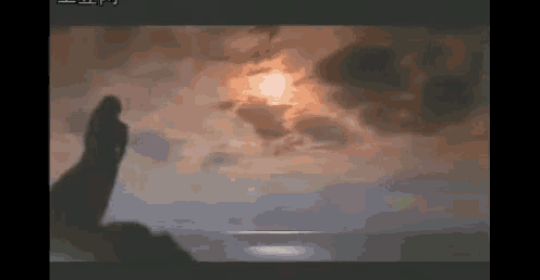 a silhouette of a person standing in front of a cloudy sky with the sun shining through the clouds .