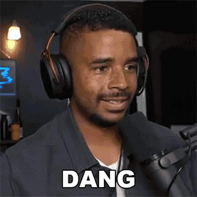a man wearing headphones and a microphone says the word dang