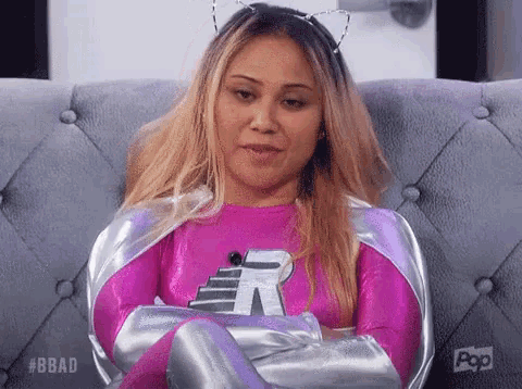 a woman in a superhero costume is sitting on a couch .
