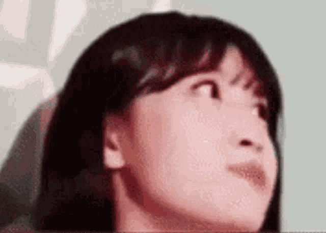 a close up of a woman 's face with her eyes closed and her mouth open .