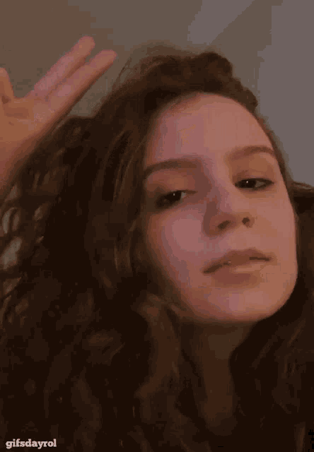 a girl making a peace sign with her hand