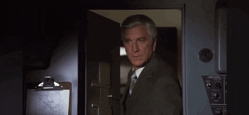 a man in a suit and tie is standing in a doorway and says we 're all counting on you