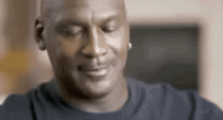 michael jordan is smiling with his eyes closed and wearing a black shirt .