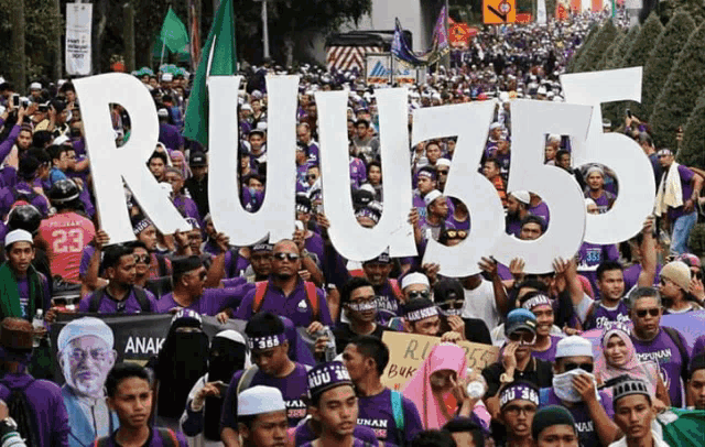 a large crowd of people holding signs that say ruj55