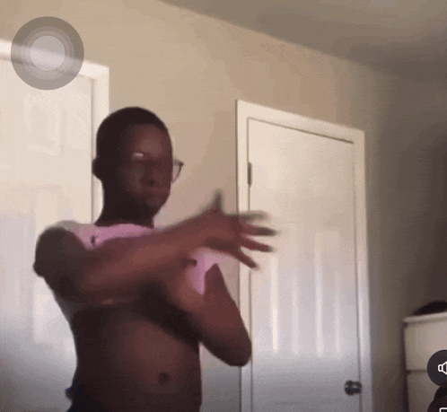 a shirtless man is standing in front of a door
