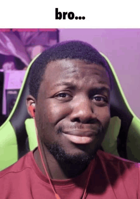 a man with a beard is wearing headphones and making a funny face while sitting in a chair .