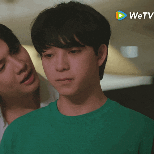a man in a green shirt is standing next to another man in a white shirt with the wetv logo in the background