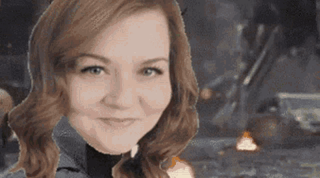 a close up of a woman 's face with a fire in the background behind her .