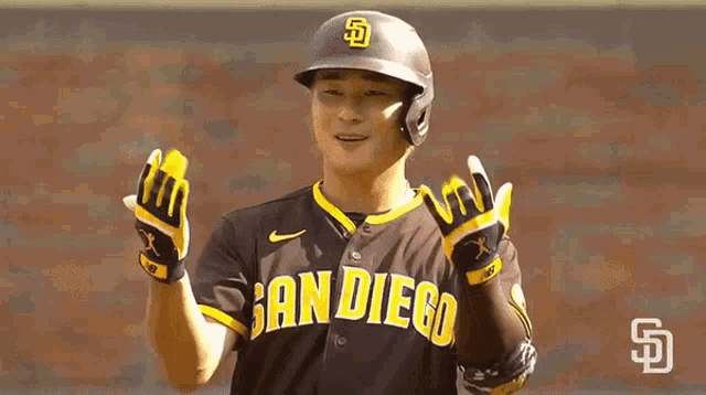 a baseball player wearing a san diego jersey and gloves is standing on the field .