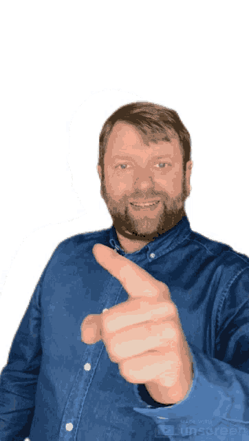 a man in a blue shirt is pointing at the camera