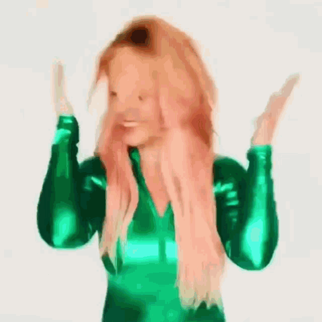 a woman with red hair is wearing a green latex outfit