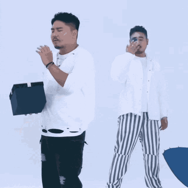 two men standing next to each other one holding a box