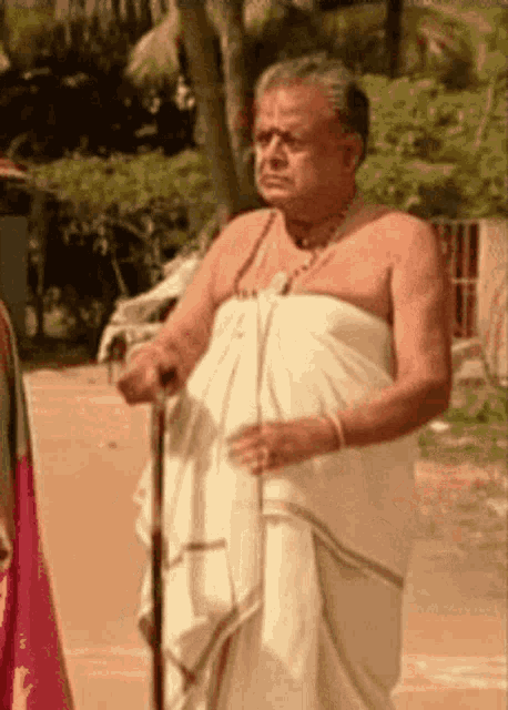 a man without a shirt is standing with a cane