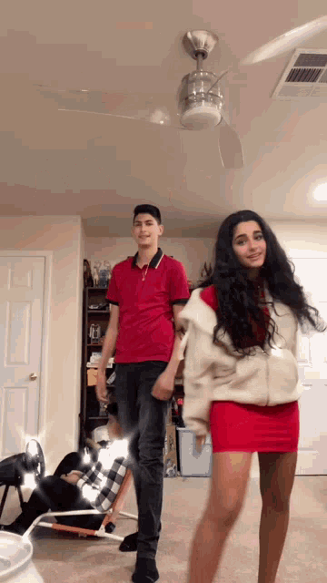 a man and a woman are dancing in a living room
