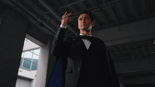 a man in a tuxedo is holding a glowing object in his hands