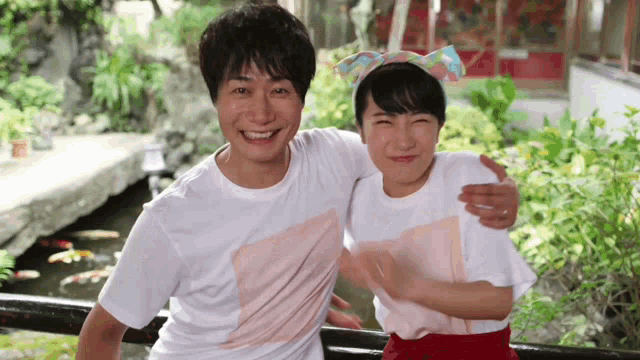 a man and a woman are posing for a picture and the man is wearing a shirt that says ' a ' on it