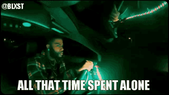 two men are sitting in a car with the words `` all that time spent alone '' written on the bottom .
