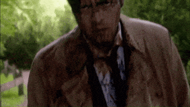 a man with blood on his jacket and tie