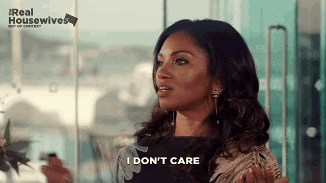 a woman says i don 't care in front of a real housewives poster