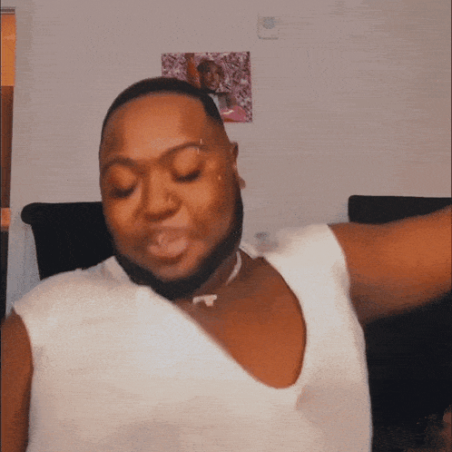 a man with a beard is wearing a white shirt and a necklace
