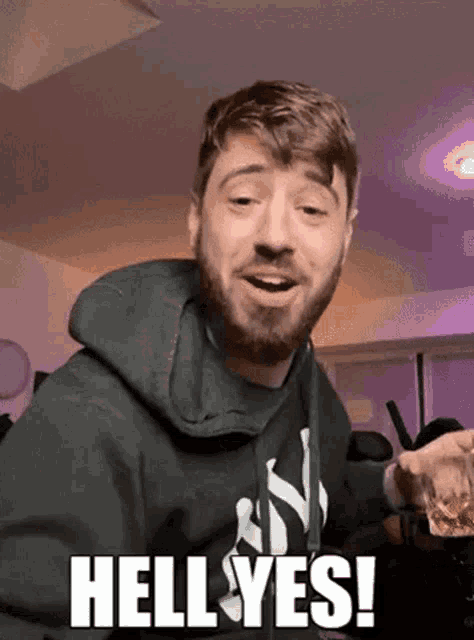 a man with a beard is making a funny face and saying hell yes