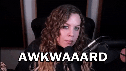 a woman is sitting in front of a microphone with the words awkward written on the screen .