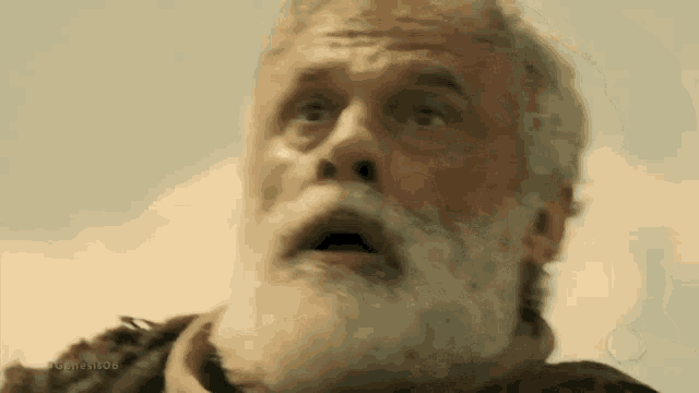 an older man with a beard is making a surprised face .