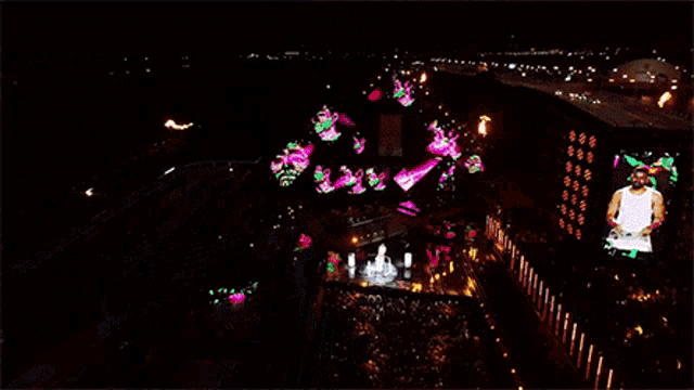 an aerial view of a stage at night with a dj playing music