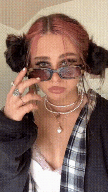 a girl with pink hair is wearing sunglasses and a necklace