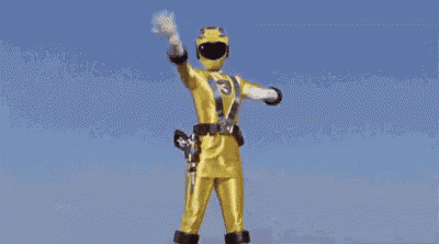 a yellow power ranger is standing in the rain with his hands up .