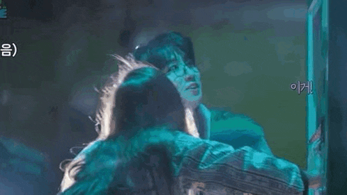 a man is hugging a woman in a dark room .