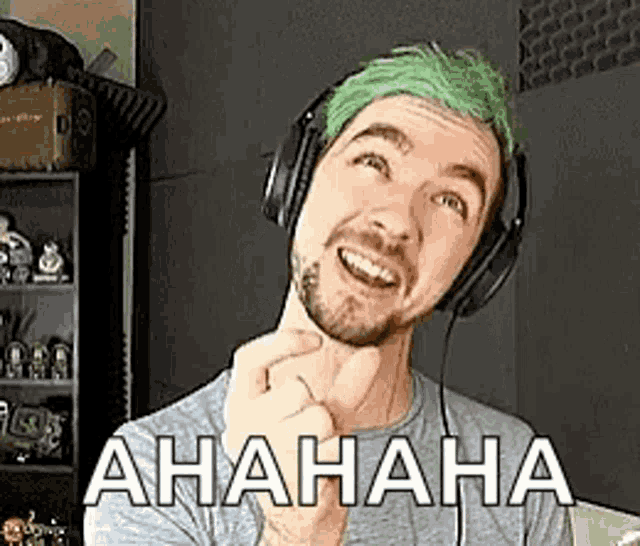 a man with green hair and headphones is making a funny face .
