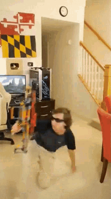 a person wearing sunglasses is doing a trick on the floor