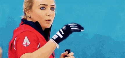 a woman in a red shirt is holding a cell phone .