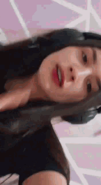 a close up of a woman wearing headphones and making a funny face .