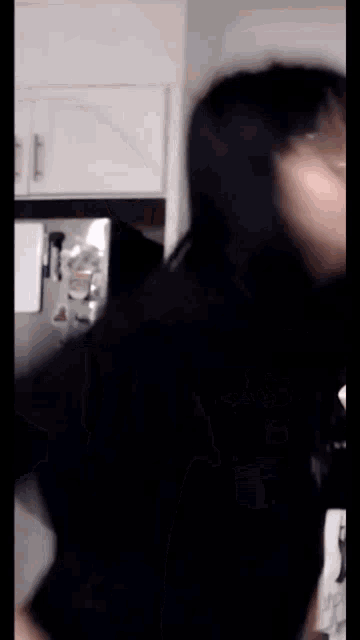 a blurry photo of a person 's face in a kitchen