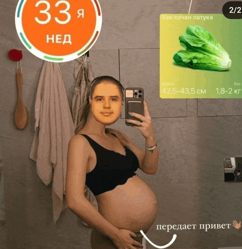 a pregnant woman taking a picture of herself in front of a mirror